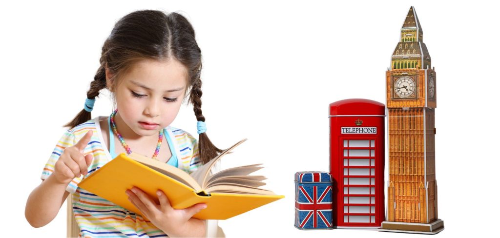 Dziewczynka w wieku przedszkolnym czyta książkę a obok w wersji miniaturowej stoi wieża, budka telefoniczna i zapakwowana w ozdobny papier paczka