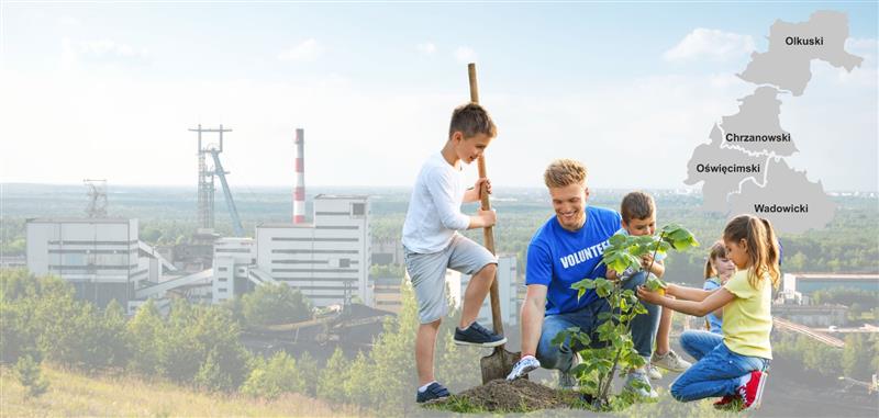 Mężczyzna z grupą dzieci sadzący drzewo, w tle krajobraz przemysłowy